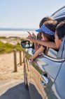 Счастливые дети, высунувшиеся из окна машины на пляже — стоковое фото