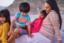 Happy mother and kids relaxing on beach — Stock Photo