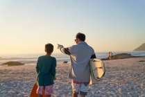 Pai e filho com pranchas de surf na praia ensolarada — Fotografia de Stock