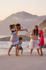 Щаслива сім'я грає на океанічному пляжі — стокове фото