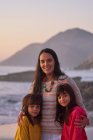 Retrato feliz madre e hijas en la playa - foto de stock