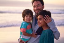 Retrato feliz pai e filhos na praia do oceano — Fotografia de Stock