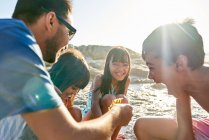Glückliche Familie spielt am sonnigen Strand — Stockfoto