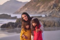 Ritratto felice madre e figlie sulla spiaggia — Foto stock