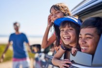 Retrato feliz crianças inclinando-se para fora ensolarado carro janela — Fotografia de Stock