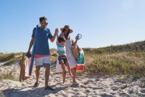 Família brincalhão andando na areia no caminho ensolarado da praia — Fotografia de Stock