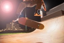 Молодой человек катается на скейтборде на рампе в скейт-парке — стоковое фото