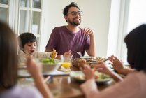 Glückliche Familie beim Essen am Tisch — Stockfoto