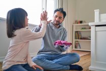 Father and daughter folding laundry and high fiving — Stock Photo