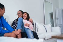 Famiglia felice sul divano del soggiorno — Foto stock