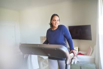 Lächelnde Frau trainiert auf Laufband — Stockfoto