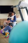 Madre e hija cariñosas abrazándose en la sala de estar - foto de stock