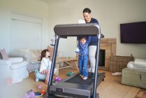 Mother and son walking on treadmill in living room — Stock Photo