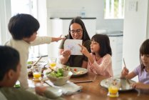 Mother and kids eating lunch at dining table — Stock Photo