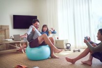 Padre juguetón y niños haciendo ejercicio en la sala de estar - foto de stock