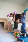 Mother and kids exercising with dumbbells in living room — Stock Photo