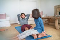 Playful father and daughter exercising in living room — Stock Photo