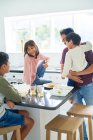 Padre e figli mangiano cibo da asporto in cucina — Foto stock