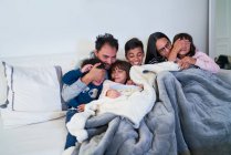 Familia feliz viendo películas de miedo en el sofá de la sala de estar - foto de stock