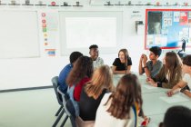 Studenti delle scuole superiori che parlano a tavola in classe dibattito — Foto stock