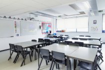 Mesas em sala de aula vazia — Fotografia de Stock