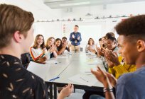 Alunos do ensino médio e professor aplaudindo para aluno em aula de debate — Fotografia de Stock