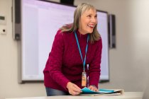 Instrutora confiante e feliz preparando-se em sala de aula — Fotografia de Stock