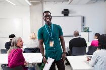 Retrato feliz, confiante macho comunidade instrutor universitário lição de liderança em sala de aula — Fotografia de Stock