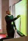Männlicher Lehrer leitet Unterricht an Projektionswand im Klassenzimmer — Stockfoto