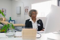 Female senior doctor working at computer in doctors office — Stock Photo