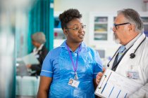 Männliche Ärztin und weibliche Krankenschwester reden im Krankenhaus — Stockfoto