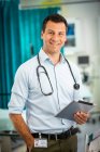 Portrait confident male doctor with digital tablet in hospital — Stock Photo