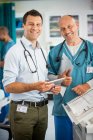 Портрет уверенный врачи-мужчины с помощью цифрового планшета в больнице — стоковое фото