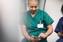 Мужской хирург с помощью смартфона — стоковое фото