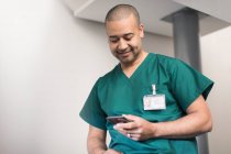 Мужской хирург с помощью смартфона — стоковое фото
