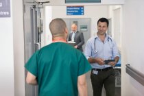 Врачи-мужчины приветствуют друг друга в больничном коридоре — стоковое фото