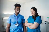 Portrait confident female nurse and doctor in hospital room — Stock Photo