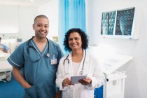 Портрет уверенных врачей с цифровым планшетом в больничной палате — стоковое фото