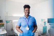 Enfermera sonriente y confiada en retratos en la habitación del hospital - foto de stock