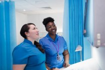 Ärztin und Krankenschwester untersuchen Röntgenbilder im Krankenhauszimmer — Stockfoto