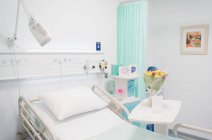 Bouquet de fleurs et carte Get Well sur plateau dans la chambre d'hôpital vacante — Photo de stock