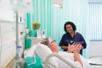 Lächelnder Arzt macht Runde, spricht mit Seniorin im Krankenzimmer — Stockfoto