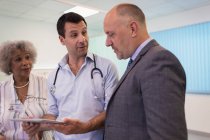 Лікарі з цифровим планшетом роблять раунди, консультування в лікарні — стокове фото