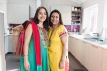 Portrait happy Indian sisters in traditional saris in kitchen — Stock Photo