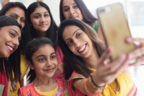 Felice donne e ragazze indiane in saris prendendo selfie — Foto stock