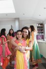 Retrato feliz madre india e hija en saris abrazándose en la cocina - foto de stock