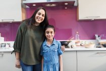 Ritratto felice madre e figlia indiana cucina il cibo in cucina — Foto stock