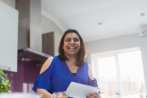 Porträt einer glücklichen Frau mit digitalem Tablet in der Küche — Stockfoto