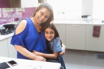Портрет щаслива мати і дочка обіймаються на кухні — стокове фото