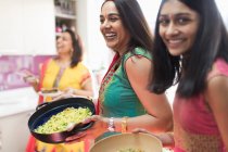 Felice donne indiane in sari cucinare cibo in cucina — Foto stock